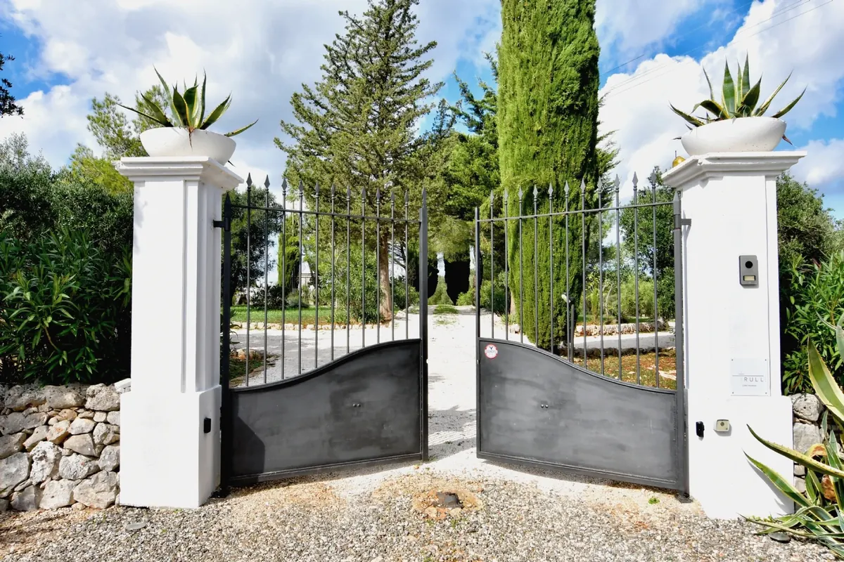The entrance gate between the cypresses