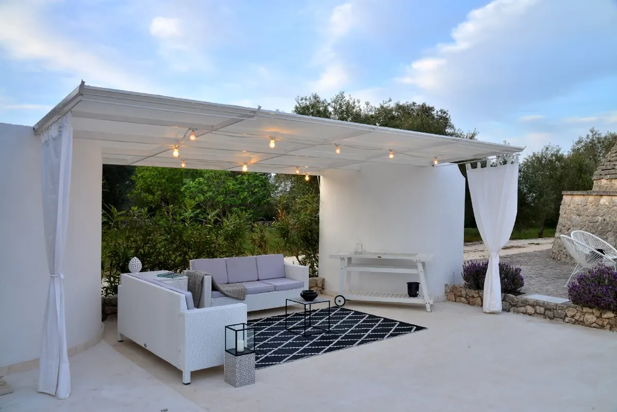 The gazebo with white sofas and the rug