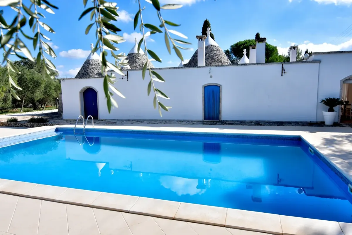 La piscina privata e le porte blu, fra i rami di ulivo